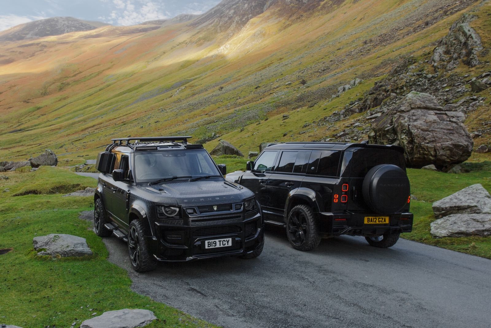 Land Rover Defender verde-oliva em terreno externo ao amanhecer